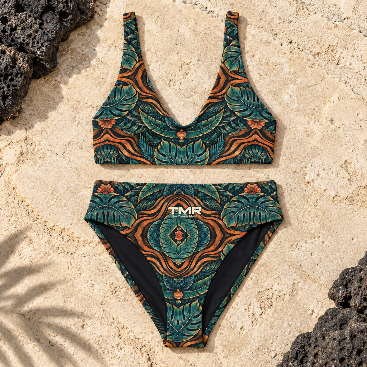 Bikini Tigre Noctámbulo de cintura alta — TMR by Tamar Melián 1 Vista frontal del bikini Tigre Noctámbulo: top de tirantes anchos y braguita de cintura alta, con estampado verde petróleo y naranja, firma TMR en el frontal y fondo de piedra clara.