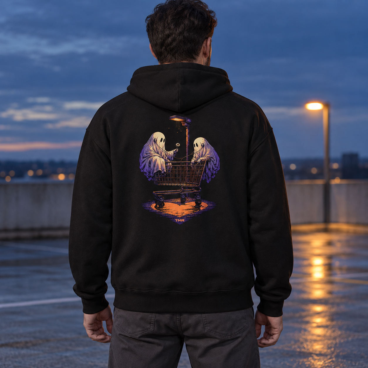 Fantasmas del parking — Sudadera 1 Sudadera negra Fantasmas del parking de TMR, vista de espalda en modelo adulto con dos fantasmas y un carrito bajo una farola