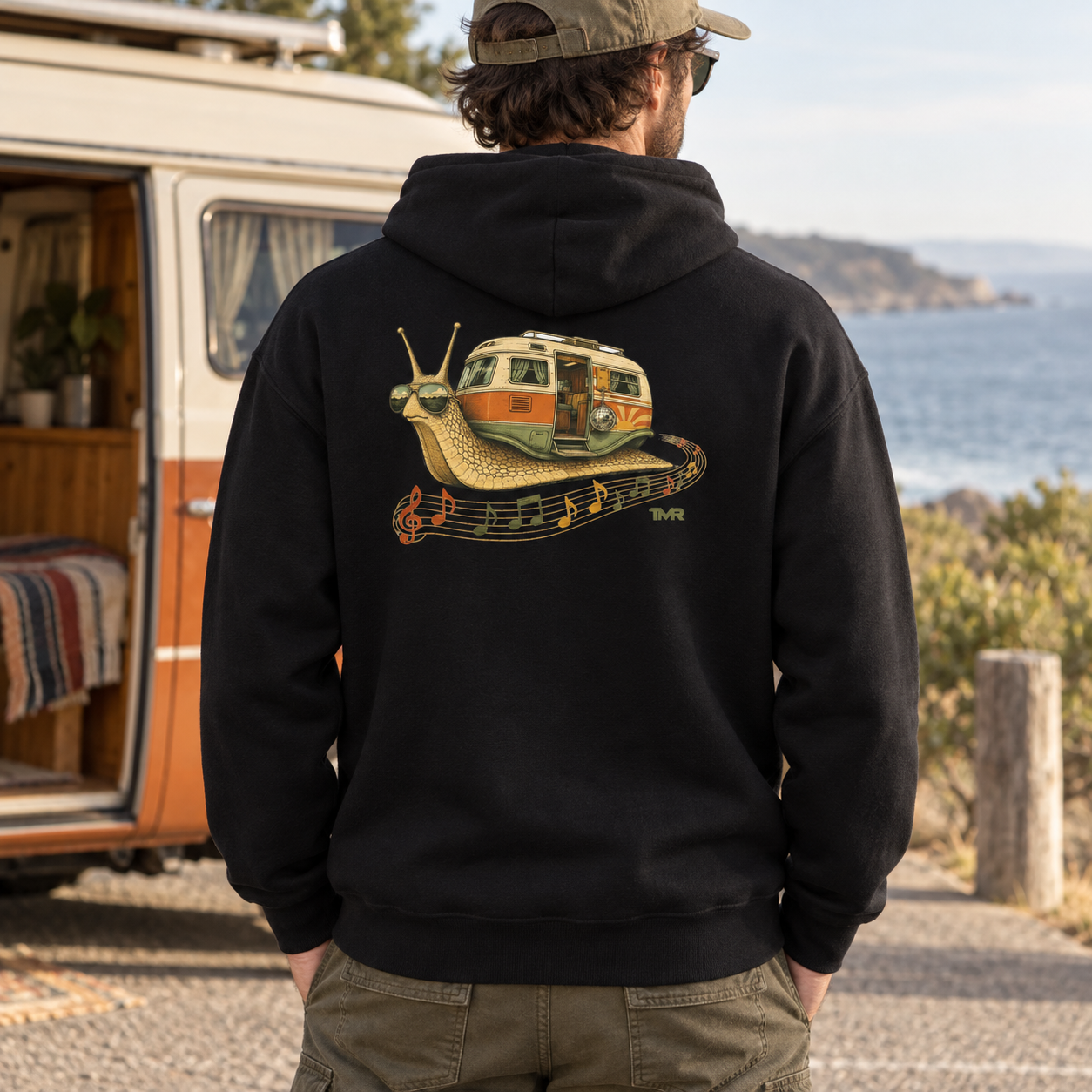 Furgo caracol — Sudadera 1 Sudadera negra Furgo caracol TMR vista de espalda junto a una camper en la costa