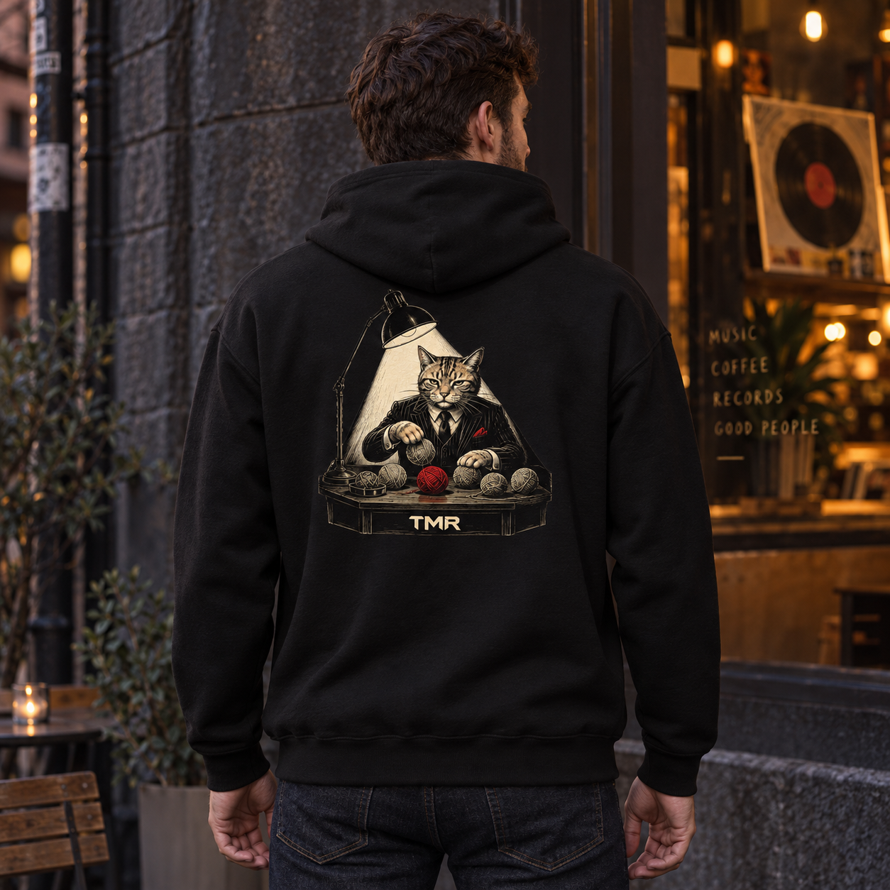 El padrino del ovillo — Sudadera 3 Sudadera negra El padrino del ovillo de TMR by Tamar Melián, estampado de espalda en un modelo adulto ficticio.