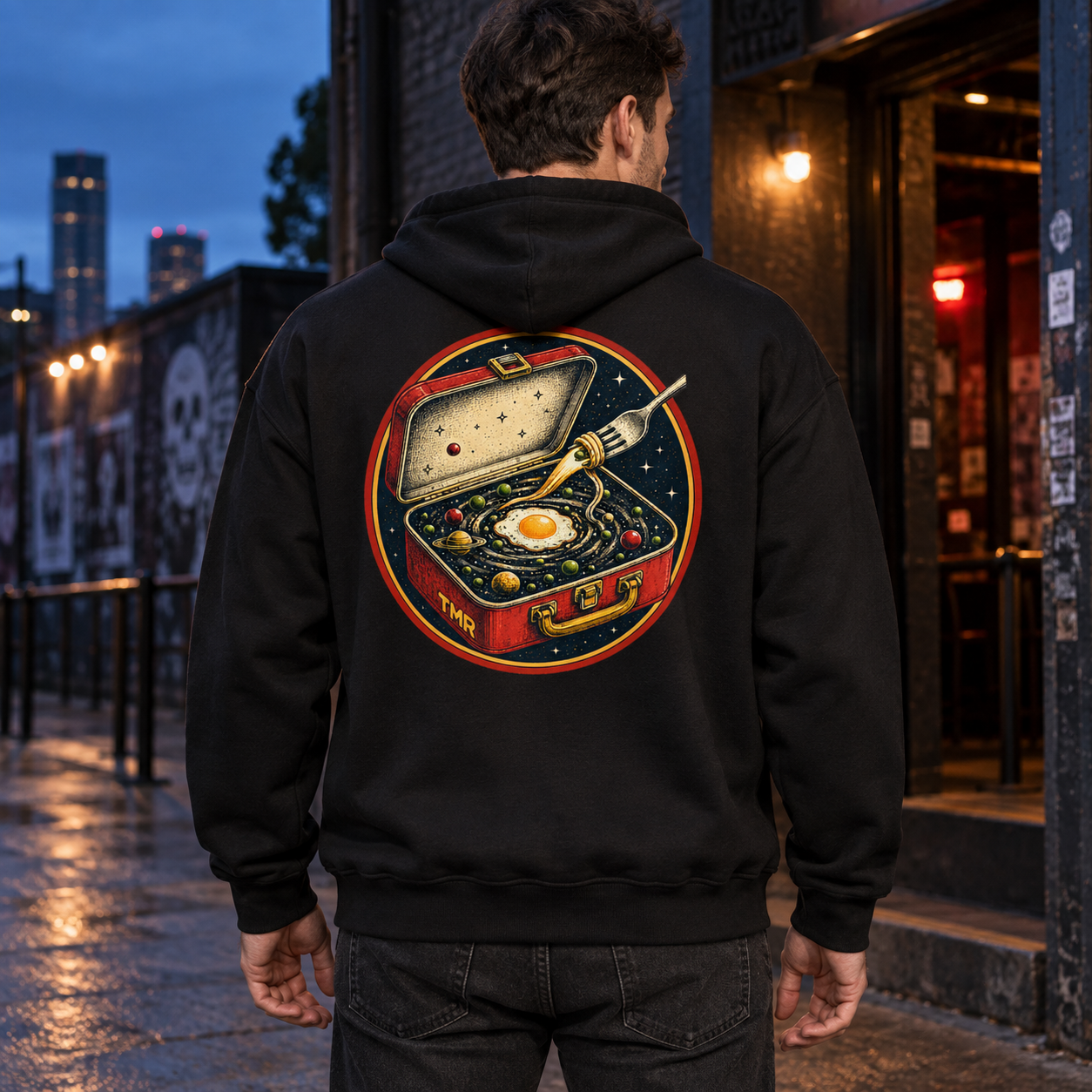 Tupper interdimensional — Sudadera 1 Sudadera negra Tupper interdimensional TMR en un modelo adulto de espaldas, con la ilustración completa de la fiambrera cósmica.